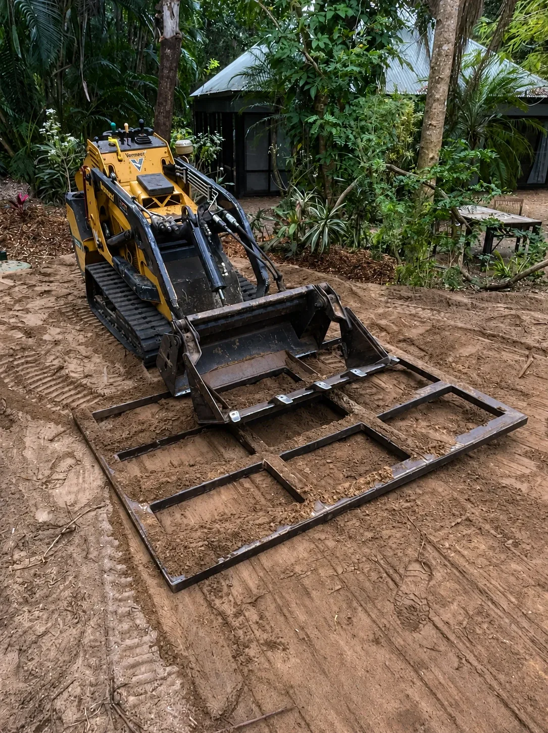 Operator using a Bundy Dingo mini loader in a tight backyard